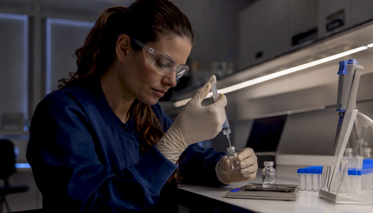 Researcher preparing peptide dosage in lab