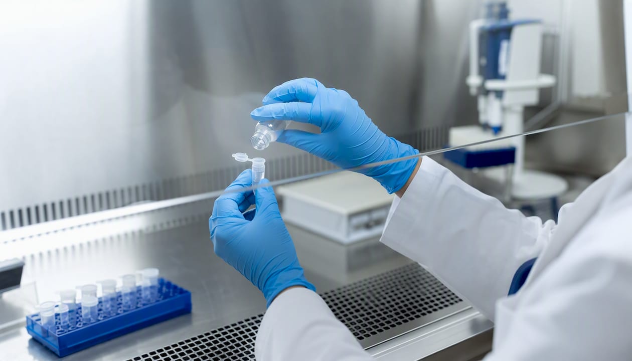 Gloved hands pipetting peptide solution sterilely
