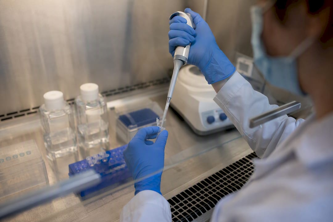 Hands preparing multi-agonist peptide in biosafety cabinet