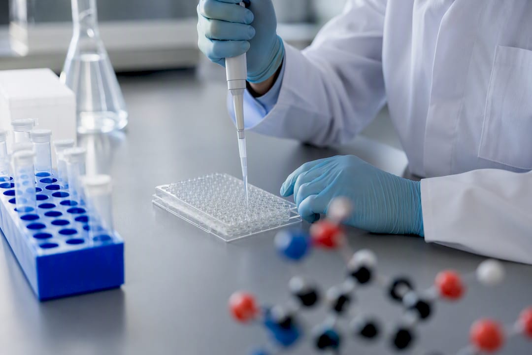Hands pipetting enzyme assay in lab